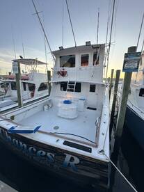 The exterior view of the 'Chances R' fishing charter boat docked at a marina, showcasing its spacious deck and amenities.