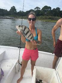 A proud angler holding a striped fish while fishing on a boat, showcasing a successful catch during a fun day on the water.