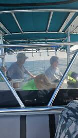Two anglers seated at the helm of a center console boat, enjoying a day on the water.