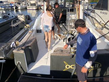 A group of anglers preparing for a fishing trip on a charter boat, showcasing the interior layout with fishing gear ready for use.