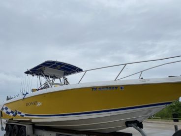 A vibrant yellow Donzi boat with a T-top, showcasing fishing rods and ready for a day on the water.