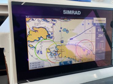 Close-up of a SIMRAD navigation display showing detailed marine charts and GPS information, ideal for navigating fishing spots.