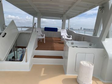 Interior view of a spacious fishing boat featuring comfortable seating and a clean deck, ideal for family fishing trips.