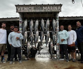 Group of anglers proudly posing in front of a catch board displaying multiple large Yellowfin Tuna at Venice Marina, known for its excellent fishing opportunities.