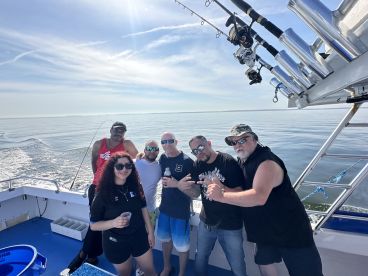 Group of anglers enjoying a day on the water aboard a fishing charter, showcasing a relaxed atmosphere with calm seas.
