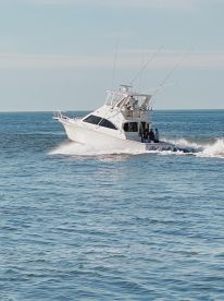 A sleek sportfishing boat cruising through calm waters, showcasing its impressive design and fishing capabilities.
