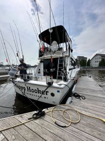 The 'Happy Hooker' charter boat docked in Sheboygan, WI, showcasing multiple fishing rods ready for action.