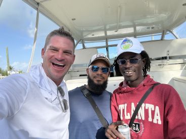 Three individuals enjoying a moment inside a boat, showcasing a relaxed atmosphere before heading out for a fishing adventure.